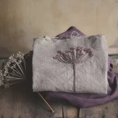 fleur brodée avec de la bourrette de soie teinte naturellement sur un carré de lin naturel